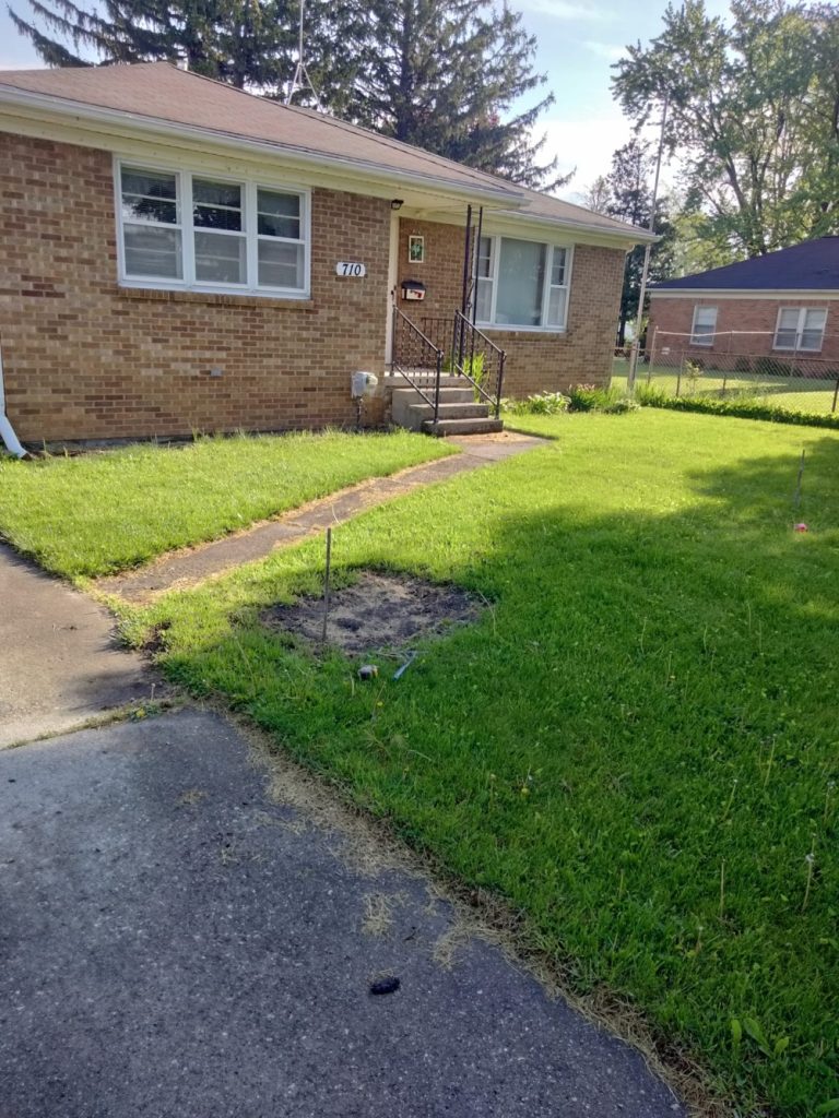 Before picture of a sidewalk leading up to front porch before renovation.