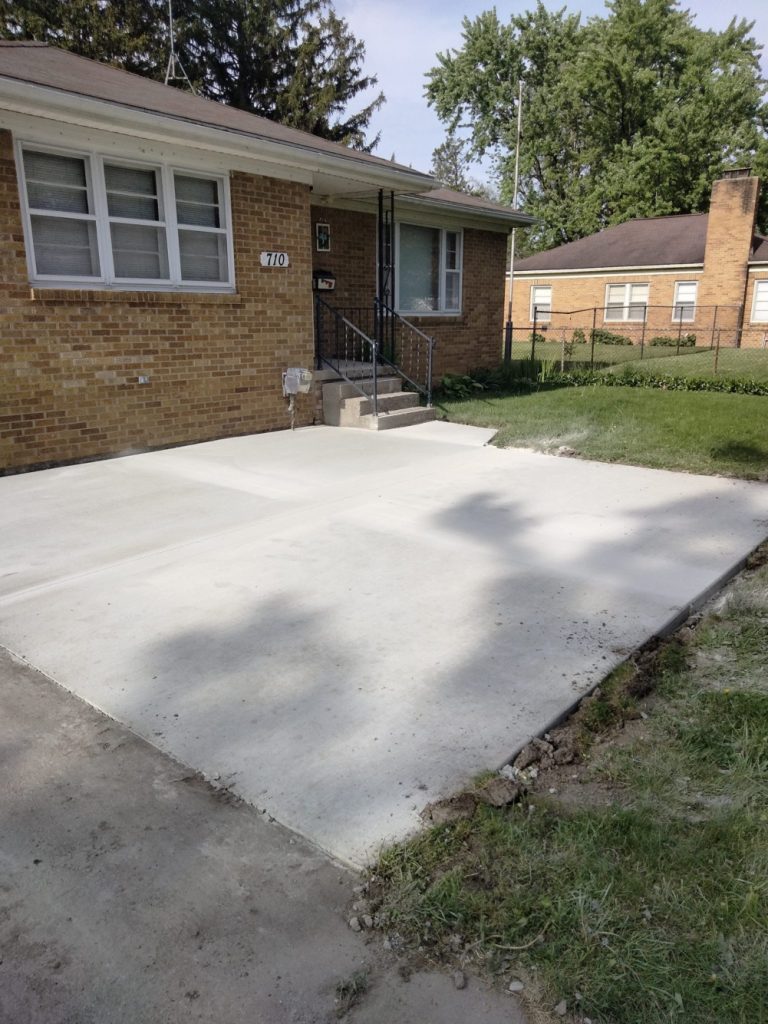 Finished concrete project in front of a home leading up to porch.