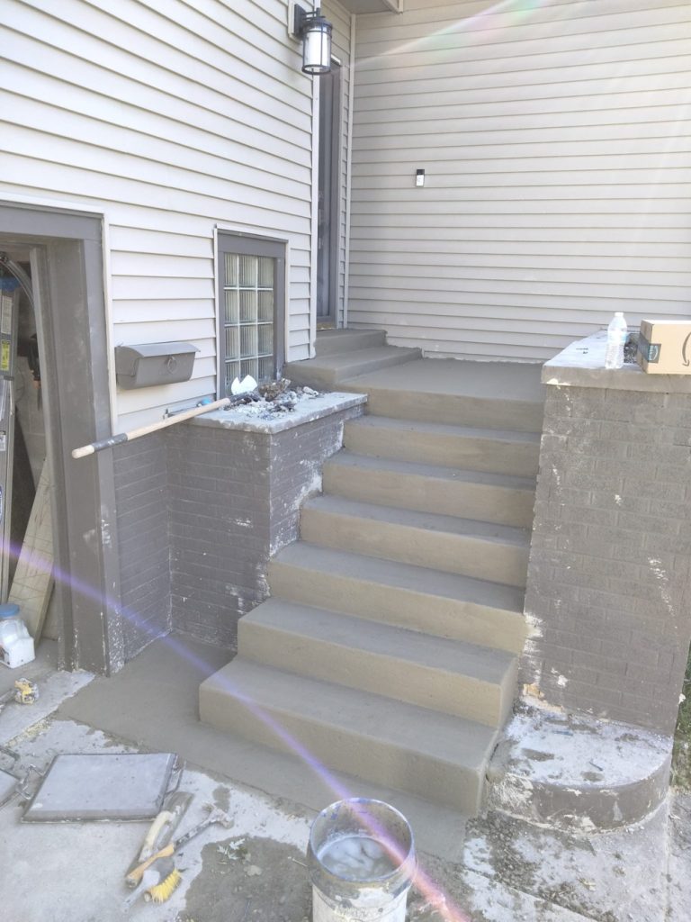 Picture of stairs of a front patio with finished concrete.